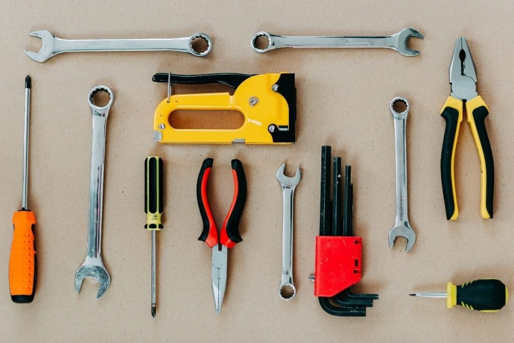 Tools of various types laid out on a brown surface, emphasizing their unique features and craftsmanship.